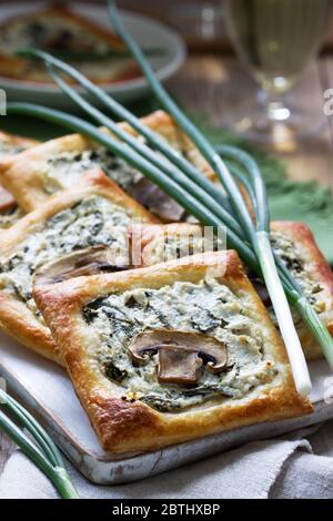 Choux au fromage, aux épinards et aux champignons, servis avec du vin et des oignons verts. Style rustique. Banque D'Images