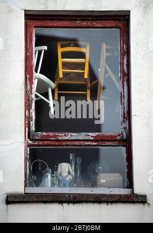 Chaises pour enfants suspendues dans une vitrine de magasin d'antiquités, Royaume-Uni Banque D'Images