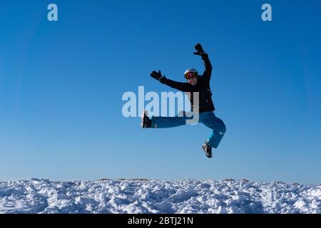 Fille avec des lunettes et un casque est en plein air en hiver. Ciel bleu et soleil éclatant au sommet des montagnes en Suisse. Concept. Banque D'Images