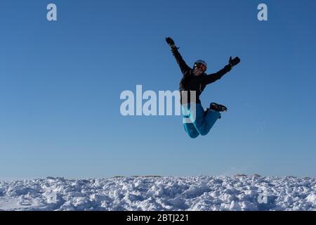 Fille avec des lunettes et un casque est en plein air en hiver. Ciel bleu et soleil éclatant au sommet des montagnes en Suisse. Concept. Banque D'Images