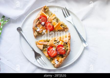Tranches de tarte aux fraises et à la rhubarbe sur une assiette blanche. Vue de dessus. Boulangerie maison. Banque D'Images
