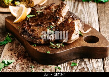 Bifteck de côtes aux herbes et à l'ail sur une table en bois rustique Banque D'Images