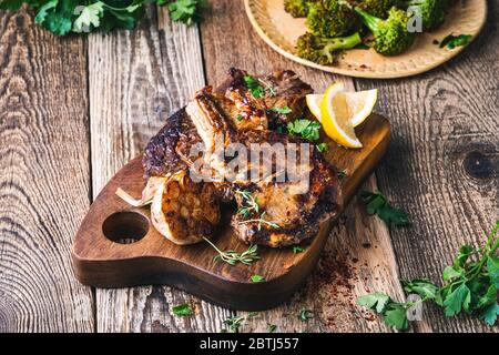 Steak de bœuf aux yeux avec broccolini, herbes et ail sur une table en bois rustique Banque D'Images