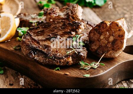 Bifteck de côtes aux herbes et à l'ail sur une table en bois rustique Banque D'Images