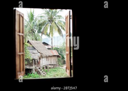 Vue par une fenêtre sur les autres maisons dans un petit village près du Mékong, du nord du Laos, de l'Asie du Sud-est Banque D'Images