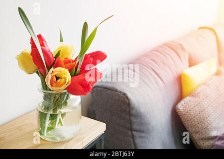 Tulipes rouges et jaunes dans un vase en verre gros plan o Banque D'Images