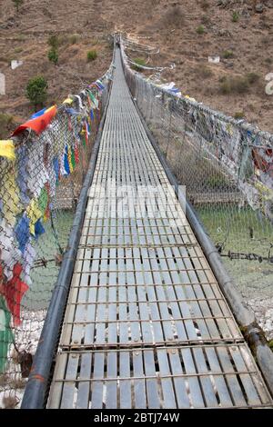 Bhoutan, Punakha. Pont suspendu de Punakha, drapé de drapeaux de prière, enjambant le Tsang Chhu aka po Chhu. Pont suspendu le plus long du Bhoutan. Banque D'Images