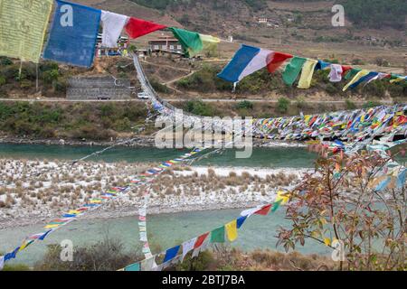 Bhoutan, Punakha. Pont suspendu de Punakha, drapé de drapeaux de prière, enjambant le Tsang Chhu aka po Chhu. Pont suspendu le plus long du Bhoutan. Banque D'Images