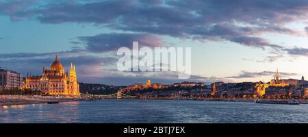 Le Parlement de Budapest s'est illuminé au coucher du soleil, vu d'une promenade en bateau sur le Danube Banque D'Images