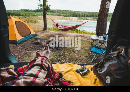 vue sur la personne couple se reposant au camping femme pontant dans hamac avec belle vue sur le lac forestier Banque D'Images