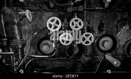 Photo en noir et blanc des vannes et robinets de l'ancien moteur de train à vapeur Banque D'Images