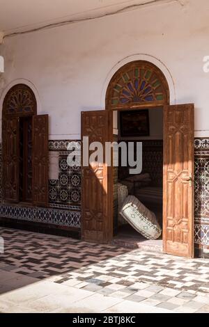 Partie bien conservée d'un complexe abandonné. Jardin avec pavage, tuiles traditionnelles de motif floral sur les murs et porte en bois ouverte. Dar Caïd Hadji (États-Unis Banque D'Images