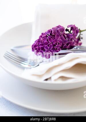 Table de printemps avec branche lilas sur serviette en lin blanc Banque D'Images