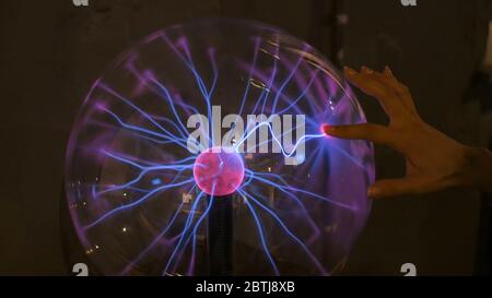 Exposition interactive au Musée des sciences. Woman touching boule de plasma. L'électricité et de physique concept Banque D'Images