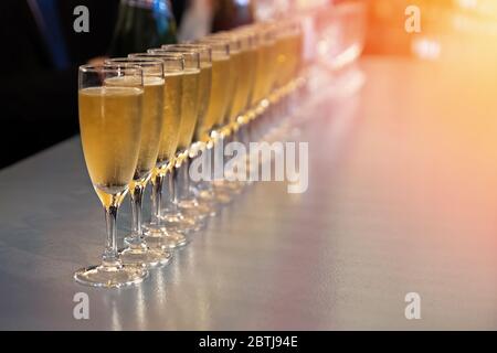Rangée de verres avec vin mousseux, champagne ou gros plan proseco. Dégustation de vin, photo aux tons chauds Banque D'Images