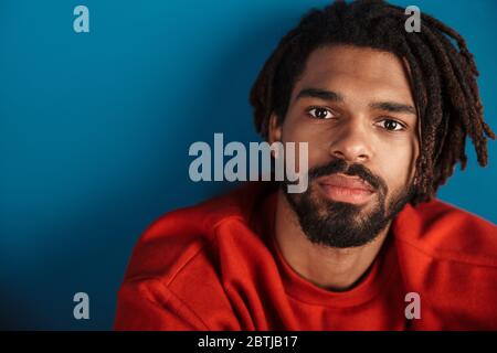 Portrait d'un homme américain africain barbu posant et regardant la caméra isolée sur fond bleu Banque D'Images
