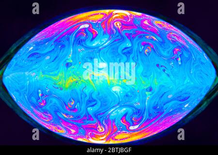 Gros plan Kaléidoscope de bulles colorées tourbillonnantes photographiées en studio avec un fond noir Banque D'Images