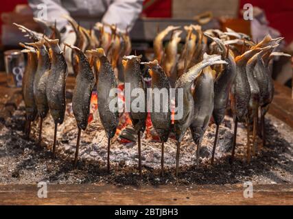 tokyo, japon - mars 30 2020: Brochettes de poisson japonais ayu également appelé poisson sucré grillé avec du sel et cuit en cercle dans un traditionnel robatayaki cuisine Banque D'Images