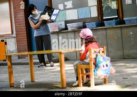 Ivrea, Italie. 26 mai 2020. IVREA, ITALIE - 26 mai 2020 : un professeur lit un livre à l'enfant de la maternelle dans un jardin scolaire. La municipalité d'Ivrea ouvre les jardins de deux écoles maternelles dans le cadre d'un test pilote pour voir comment les écoles peuvent rouvrir après le confinement du coronavirus COVID-19. (Photo de Nicolò Campo/Sipa USA) crédit: SIPA USA/Alay Live News Banque D'Images