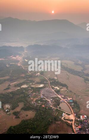 Vue aérienne depuis un ballon à air chaud au-dessus de la ville de Vang Vieng et des montagnes calcaires au lever du soleil. Vang Vieng, Laos, Asie du Sud-est Banque D'Images