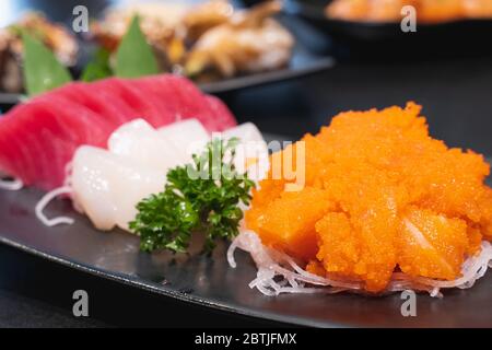 Sushi japonais. Sushi tobiko mélangé au saumon dans une assiette en céramique. Cuisine japonaise Banque D'Images