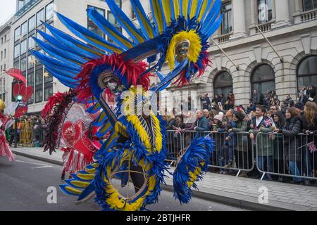 Défilé du jour de l'an à Londres 2020, homme habillé en grand costume de carnaval rouge, bleu et jaune. Banque D'Images