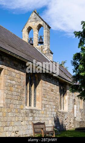 L'église de campagne de Saint Everilda à Poppleton près de York. Un banc est placé contre un mur et un clocher est au-dessus. Banque D'Images