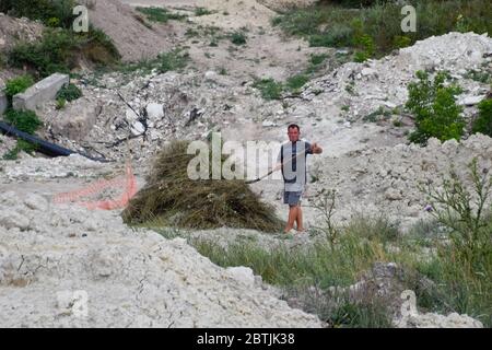 Un homme plie le foin en jupe. Un foin cop. Récolte du foin. Banque D'Images