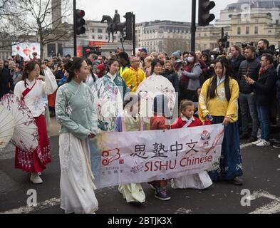 Femmes et enfants vêtu traditionnel portant une bannière chinoise Sishu. Parade de la célébration du nouvel an chinois. Londres Banque D'Images