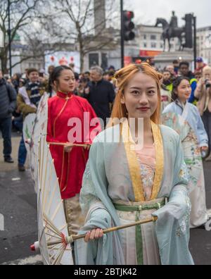 Jolie dame aux cheveux rouges dans la robe chinoise traditionnelle tenant un parapluie. Parade de la célébration du nouvel an chinois. Londres Banque D'Images