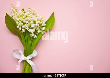 Lily de la vallée fleurit. Bouquet de Lily de la vallée fleurit sur fond rose. Flat lay, vue de dessus, espace de copie Banque D'Images
