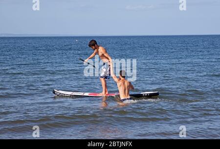 Portobello, Édimbourg, Écosse, Royaume-Uni. 26 mai 2020. Une atmosphère plus détendue au bord de la mer en fin d'après-midi alors que l'Écosse approche de la fin de la phase 1 du programme de verrouillage du coronavirus. Température de 19 degrés et ensoleillé. Photographié les frères Harrison, profitez du stand up paddle board. Banque D'Images