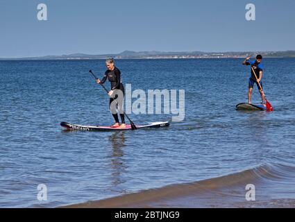 Portobello, Édimbourg, Écosse, Royaume-Uni. 26 mai 2020. Une atmosphère plus détendue au bord de la mer en fin d'après-midi alors que l'Écosse approche de la fin de la phase 1 du programme de verrouillage du coronavirus. Température de 19 degrés et ensoleillé. Sur la photo de la famille Harrison, maman et ses fils aiment monter paddle-board. Banque D'Images