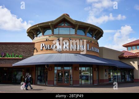 Des acheteurs masqués se promène devant un magasin Polo Ralph Lauren fermé dans les magasins de Woodburn Premium Outlets en Oregon le jour du souvenir pendant la pandémie du coronavirus. Banque D'Images