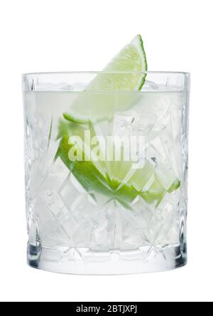 Cocktail de gimlet en verre cristal avec des glaçons et des tranches de lime isolées sur fond blanc. Banque D'Images