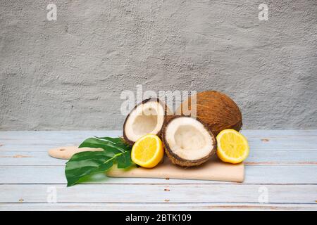 Noix de coco et citrons sur la planche à découper Banque D'Images