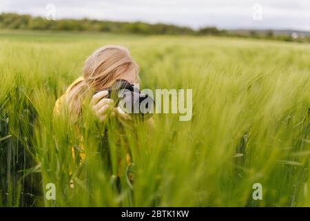 Photographe féminine prenant des photos de champ de blé vert Banque D'Images