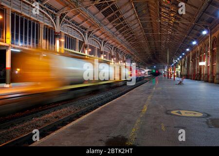 DB Cargo Rail train de fret du Royaume-Uni passant la gare de Preston sur la côte ouest de la ligne principale avec motion blur Banque D'Images