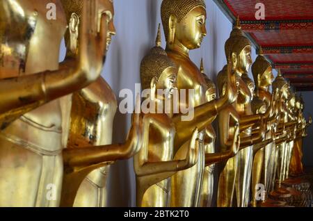 Statues de bouddha d'or debout dans une rangée à Wat Pho, Bangkok Banque D'Images