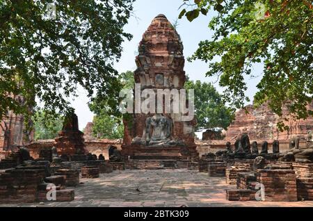 Magnifique chedi avec une statue de Bouddha assise devant, Wat Phra Mahathe à Ayutthaya Banque D'Images