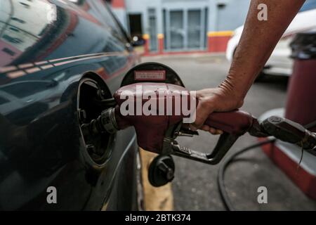 Caracas, Venezuela. 26 mai 2020. Une voiture est ravitaillée en carburant à une station-service pendant la pénurie de carburant. Le Venezuela possède d'énormes réserves de pétrole, mais en raison d'un manque de capacité de raffinage, il a beaucoup trop peu d'essence. Selon les informations iraniennes, le premier de plusieurs pétroliers iraniens avec de l'essence pour le Venezuela a atteint le pays sud-américain. Les voitures sont actuellement autorisées à remplir jusqu'à 30 litres de carburant. Crédit : Pedro Rances Mattey/dpa/Alay Live News Banque D'Images