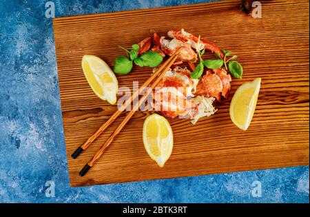 Dîner avec morceaux de homard bouillis prêts à manger à la table avec citron Banque D'Images