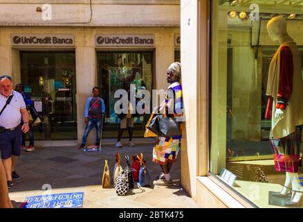 Vendeurs de sacs à main et souvenirs dans une petite rue de la ville historique de la ville métropolitaine de Venise, Italie, juin 2016 Banque D'Images