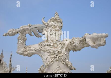 Un démon en colère laitait son arme à Wat Rong Khun, le beau temple blanc de Chiang Rai Banque D'Images