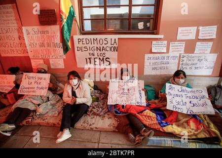 La Paz, Bolivie. 26 mai 2020. Les membres du personnel de santé portant un masque facial s'assoient sur un matelas à l'entrée de l'hôpital général de la Paz et exigent plus d'équipement de protection par une grève de la faim au milieu de la pandémie de Corona. « le couvre-feu est détendu, mais nous ne sommes pas équipés pour traiter [les patients] en cas d'augmentation immédiate des cas Covid 19 », a écrit le syndicat des travailleurs de la santé sur Twitter. Crédit : Gaston Brito/dpa/Alay Live News Banque D'Images
