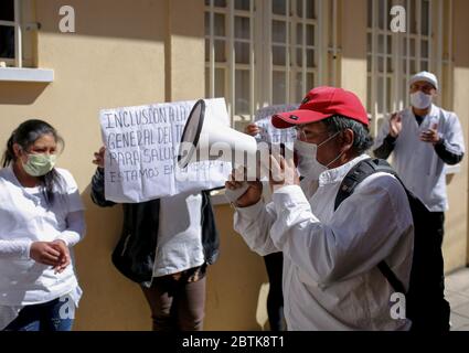 La Paz, Bolivie. 26 mai 2020. Un agent de santé cria des slogans à travers un mégaphone à l'extérieur de l'hôpital général de la Paz après avoir fait une grève de la faim au milieu de la pandémie de Corona pour exiger plus d'équipement de protection. « le couvre-feu est détendu, mais nous ne sommes pas équipés pour traiter [les patients] en cas d'augmentation immédiate des cas Covid 19 », a écrit le syndicat des travailleurs de la santé sur Twitter. Crédit : Gaston Brito/dpa/Alay Live News Banque D'Images