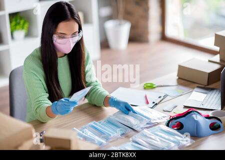 Photo de la chinoise occupée femme famille entreprise organisation emballage visage grippe masques médicaux propagation mondiale donation pays pauvres préparer des ensembles pour Banque D'Images