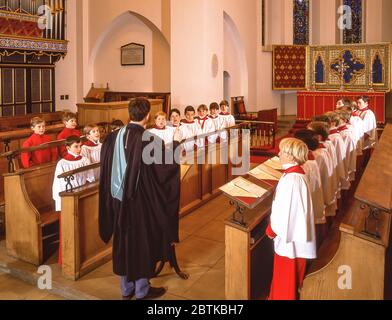 Maître de choeur dirigeant le choeur de garçon à l'église, Surrey, Angleterre, Royaume-Uni Banque D'Images