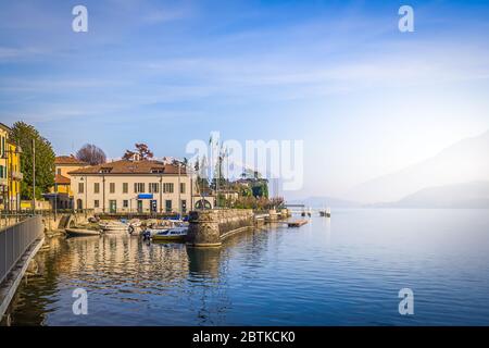 Paysage matinal apaisant avec des sommets enneigés des Alpes et une surface d'eau calme du lac de Côme sur les rives de la ville authentique de Dongo en Italie Banque D'Images