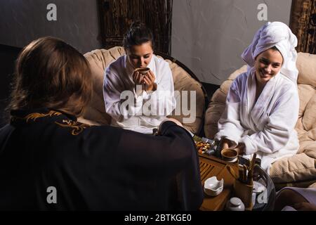 Cérémonie de thé après le sauna. Les filles en manteaux blancs boivent du thé chinois. Banque D'Images